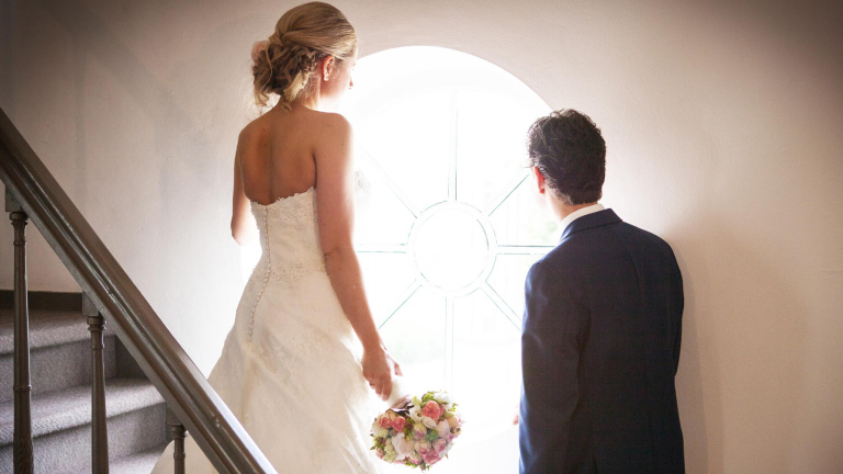 Studente staat achter bar in Le Coin en legt de laatste hand aan een rode cocktail door een schijfje limoen toe te voegen.