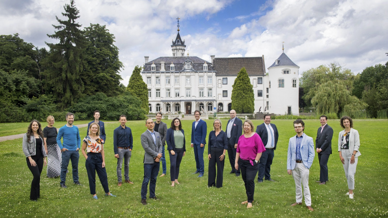 Student stands in front of the smart board in the classroom and gives presentation to his fellow students at the hotel school maastricht.