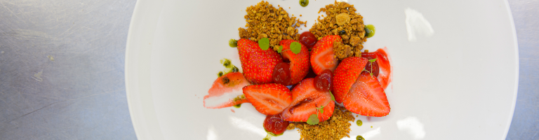 Een dessert van verse aardbeien klaar om geserveerd te worden in het restaurant van Teaching Hotel Château Bethlehem.
