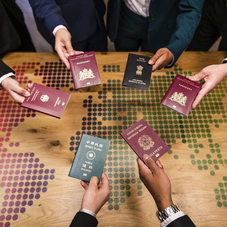 International students holding their passports over a table