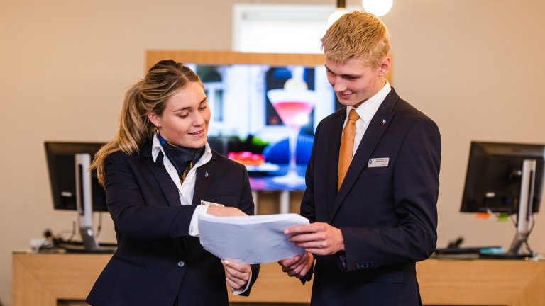 Female student pours milk into a kettle in the kitchen of restaurant l'Etoile.