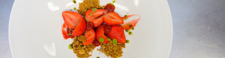 Een dessert van verse aardbeien klaar om geserveerd te worden in het restaurant van Teaching Hotel Château Bethlehem.