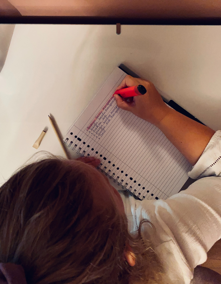Merel Nijsten writing her to-do list sitting at her desk with a notebook and a pink marker