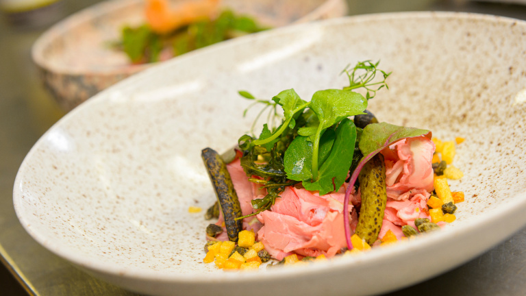 Een kleurrijk zomers voorgerecht met koud vlees klaar om geserveerd te worden in het Teaching Hotel.