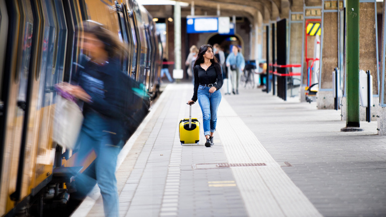 Student stands in front of the smart board in the classroom and gives presentation to his fellow students at the hotel school maastricht.