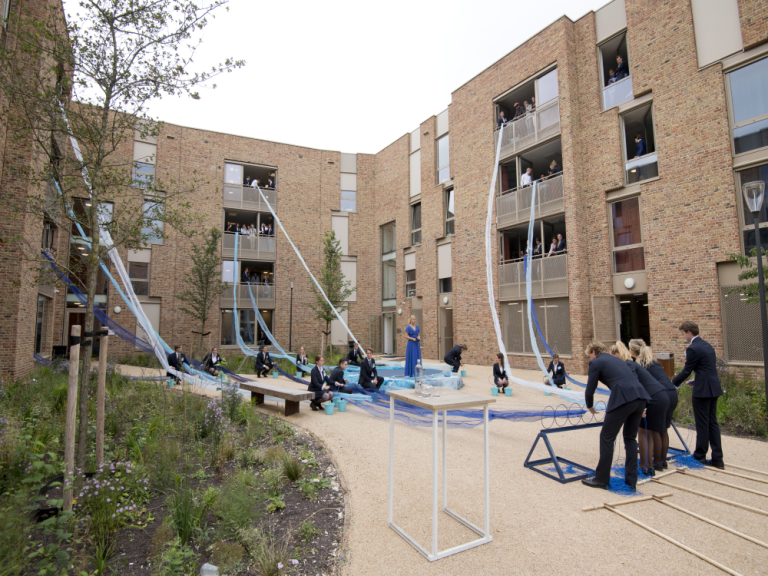The new student residence is opened by students. Flowing blue organza flows out the windows like a river.
